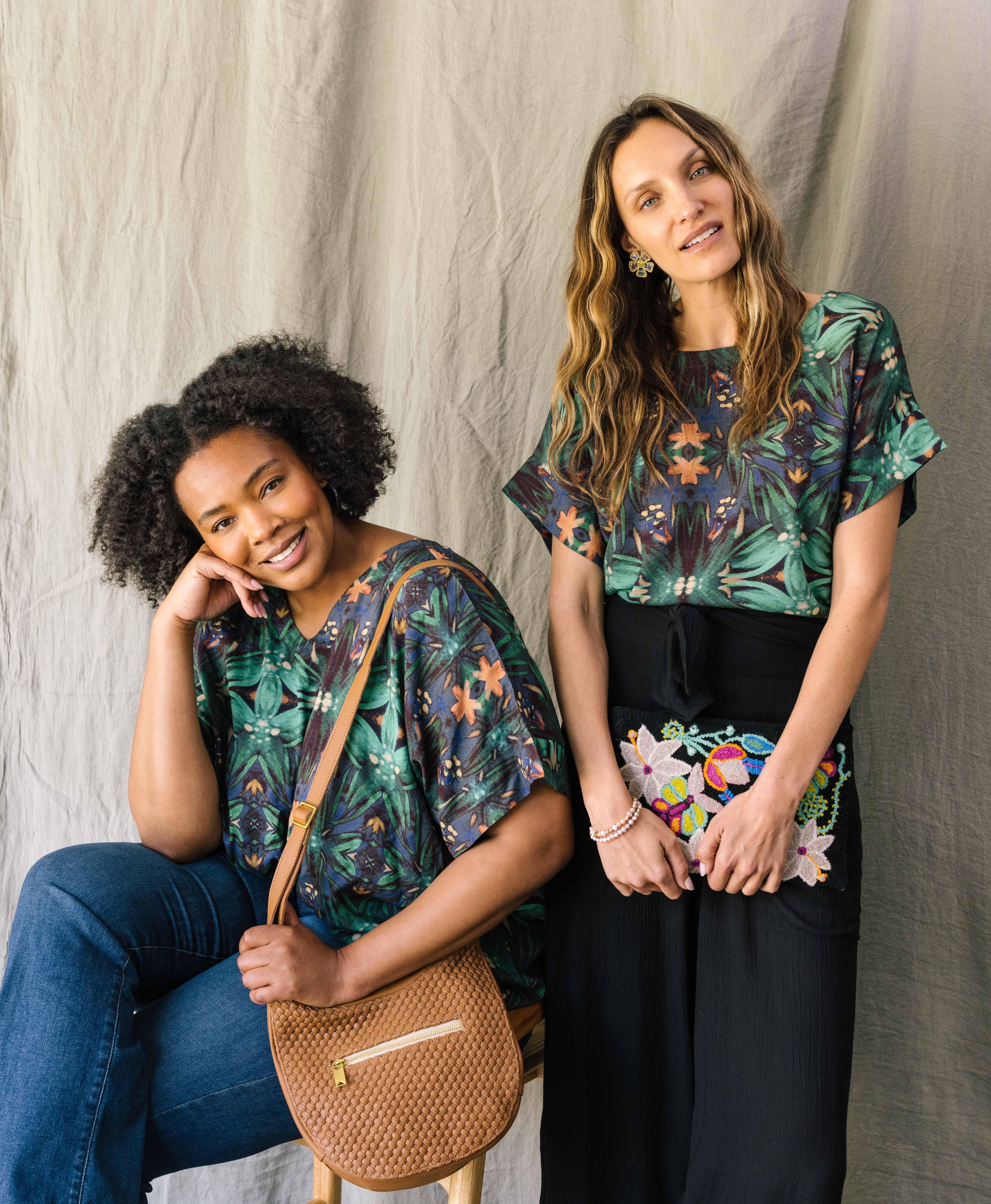 wo models wear the Crop Blouse styled two different ways. The top is short-sleeved and made of flowy rayon fabric with a lush jungle-inspired print. The model on the left wears it with the v-neck facing the front. The model on the right wears it with the crew neck facing the front.