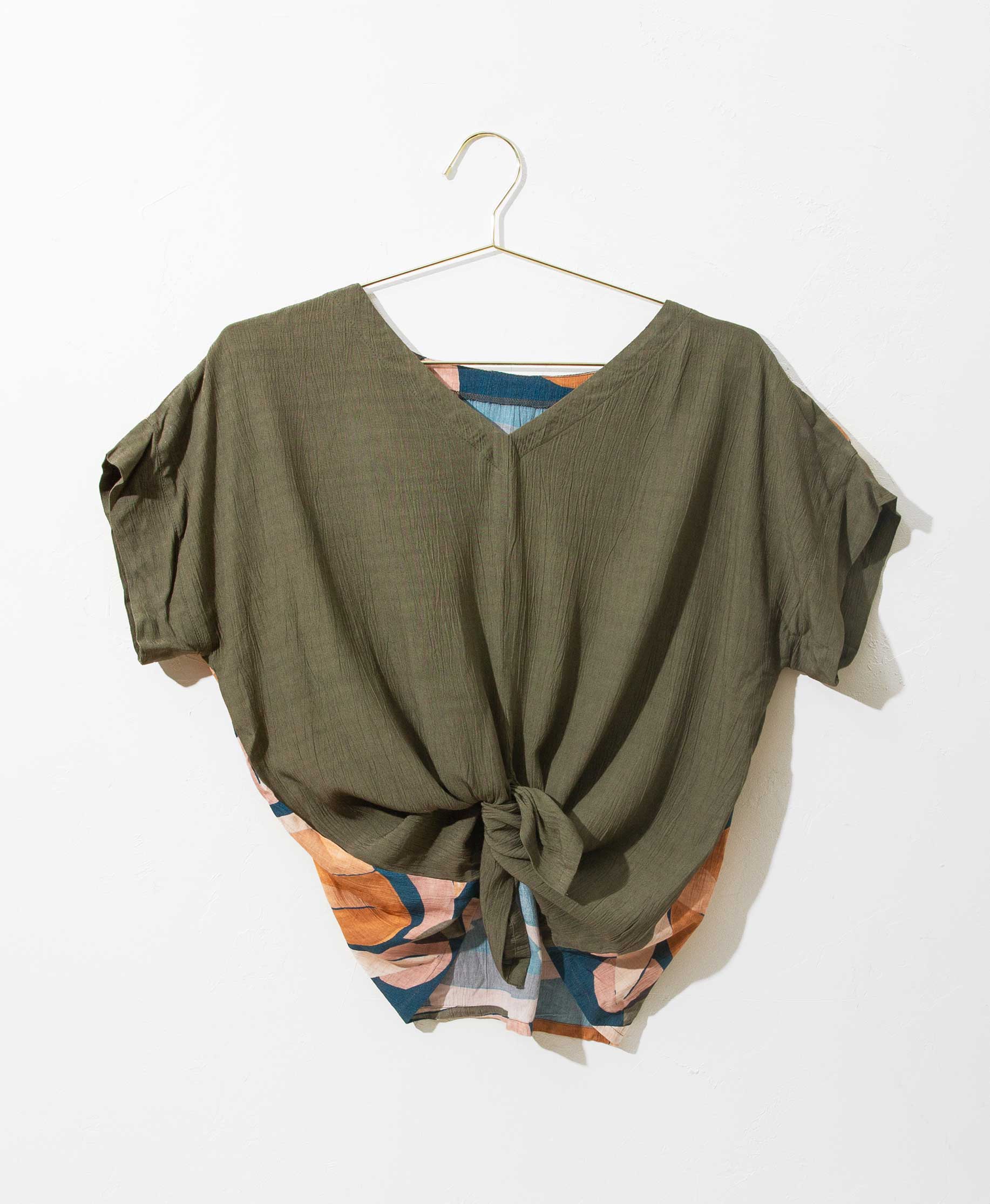 So many looks from one simple design. Wear it tied or untied for extra versatility. With our Obuvumu pattern on one side and solid olive on the other, you can style this reversible piece to suit your mood or your destination. The easy, flattering fit is another reason you'll be reaching for this blouse whether you're working from home or are on the go.